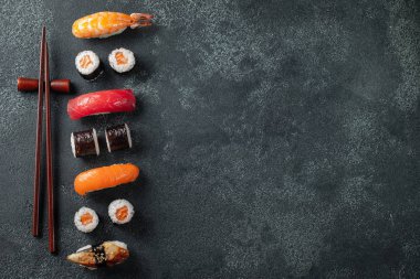 Suşi ve maki karanlık taş tablo kümesi. Üstten Görünüm kopya alanı ile. Düz yatıyordu.