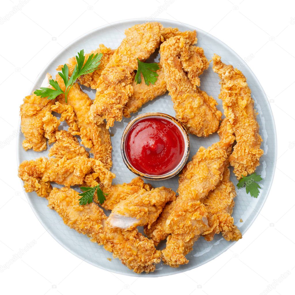 Breaded chicken strips with tomato ketchup on a white plate. Fast food on dark brown background. Top view.