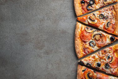 Dilimleri lezzetli taze pizza sosis sucuk ve peynir ile karanlık bir arka plan üzerinde kesmek. Üstten görünüm metin için kopya yer ile. Pizza siyah beton masada. düz lay.