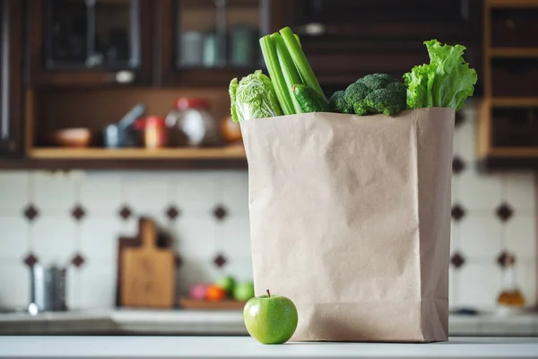 Свежие зеленые овощи и фрукты в бумажном пакете . — стоковое фото