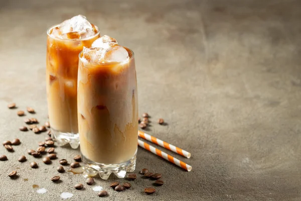 Es kopi dalam gelas tinggi dengan krim dituangkan di atas dan biji kopi. Minuman musim panas yang dingin di latar belakang coklat berkarat dengan ruang fotokopi — Stok Foto