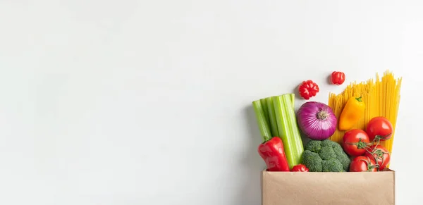 Papiertüte mit verschiedenen gesunden Lebensmitteln auf einem Tisch. — Stockfoto