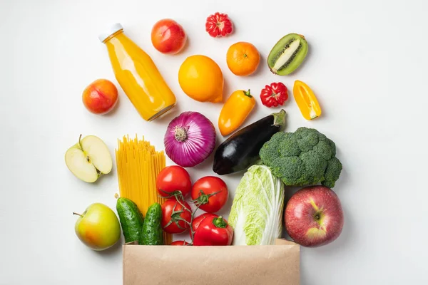 Bolsa de papel de diferentes alimentos saludables en una mesa . — Foto de Stock