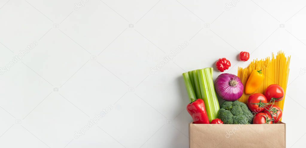 Paper bag of different healthy food on a table.