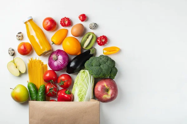 Bolsa de papel de diferentes alimentos saludables en una mesa . — Foto de Stock