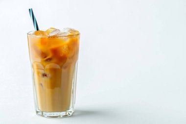 Krem üzerine dökülür ve kahve çekirdekleri ile uzun bir bardak buzlu kahve. Hafif bir arka plan üzerinde soğuk yaz içeceği. Kopya alanı ile