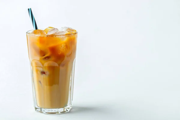 Кофе со льдом в высоком стакане со сливками и кофейными зёрнами. Холодный летний напиток на светлом фоне. С копировальным местом — стоковое фото