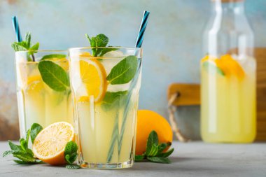İki bardak limonata ya da naneli mojito kokteyli soğuk, ferahlatıcı içecek ya da buzlu, mavi arka planda buzlu içecek.
