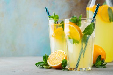 İki bardak limonata ya da naneli mojito kokteyli soğuk, ferahlatıcı içecek ya da buzlu, mavi arka planda buzlu içecek. Boşluğu kopyala