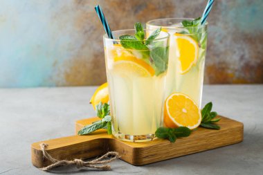 İki bardak limonata ya da naneli mojito kokteyli soğuk, ferahlatıcı içecek ya da buzlu, mavi arka planda buzlu içecek. Boşluğu kopyala