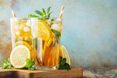 Ahşap bir rustik masada uzun bardak limon ve buz ile geleneksel buzlu çay. Kopyalama alanı ile