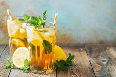 Ahşap bir rustik masada uzun bardak limon ve buz ile geleneksel buzlu çay. Kopyalama alanı ile