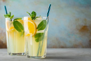 İki bardak limonata ya da naneli mojito kokteyli soğuk, ferahlatıcı içecek ya da buzlu, mavi arka planda buzlu içecek. Boşluğu kopyala