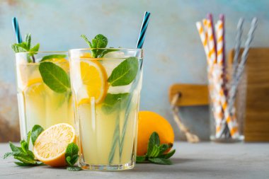 İki bardak limonata ya da naneli mojito kokteyli soğuk, ferahlatıcı içecek ya da buzlu, mavi arka planda buzlu içecek.