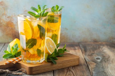 Ahşap bir rustik masada uzun bardak limon ve buz ile geleneksel buzlu çay. Kopyalama alanı ile