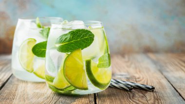 Rustik bir masada bir bardak buz küpleri ile iki Mojito kokteyl, seçici odak. Kopya alanı ile