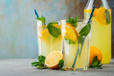 İki bardak limonata ya da naneli mojito kokteyli soğuk, ferahlatıcı içecek ya da buzlu, mavi arka planda buzlu içecek. Boşluğu kopyala