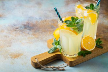 İki bardak limonata ya da naneli mojito kokteyli soğuk, ferahlatıcı içecek ya da buzlu, mavi arka planda buzlu içecek. Boşluğu kopyala