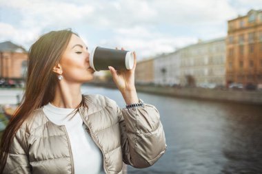 Güzel genç kız eski şehrin arka planda bir kağıt Fincan kahve içme. Metin için kopyalama alanı ile