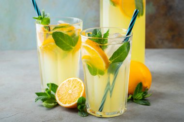İki bardak limonata ya da naneli mojito kokteyli soğuk, ferahlatıcı içecek ya da buzlu, mavi arka planda buzlu içecek.