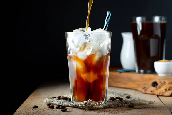 Es kopi dalam gelas tinggi dengan krim dituangkan di atas, es batu dan — Stok Foto