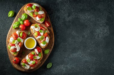 Domates, mozzarella peyniri ve fesleğen dilimleme tahtasında. Geleneksel İtalyan aperatifi veya aperatifi, antipasto. Kopyalama alanı olan üst görünüm. Düz yatıyordu