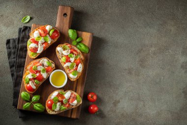 Domates, mozzarella peyniri ve fesleğen dilimleme tahtasında. Geleneksel İtalyan aperatifi veya aperatifi, antipasto. Kopyalama alanı olan üst görünüm. Düz yatıyordu