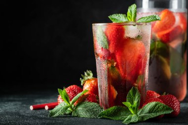 Siyah Masa arka planda cam üstünde buz, nane ve çilek ile taze limonata, kopya alanı. Soğuk yaz içeceği. Berry kokteyl ile köpüklü gözlük