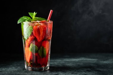 Siyah Masa arka planda cam üstünde buz, nane ve çilek ile taze limonata, kopya alanı. Soğuk yaz içeceği. Berry kokteyl ile köpüklü gözlük