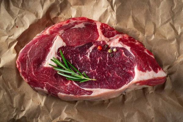Syrové hovězí steak s bylinkami a kořením na papíře. Pohled shora. Plochá ležela — Stock fotografie