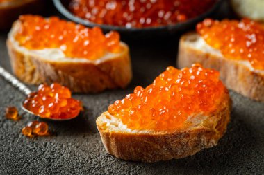 Koyu beton arka plan üzerinde kırmızı havyar ile Lezzetli Sandviçler