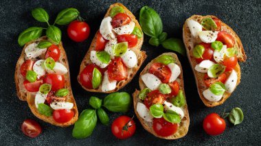 Domates, mozzarella peyniri ve fesleğen dilimleme tahtasında. Geleneksel İtalyan aperatifi veya aperatifi, antipasto. Kopyalama alanı olan üst görünüm. Düz yatıyordu