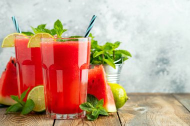 Kireç ve nane ile Karpuz slushie, açık mavi arka plan üzerinde uzun boylu gözlük yaz ferahlatıcı içecek. Kopya alanı ile tatlı soğuk smoothie