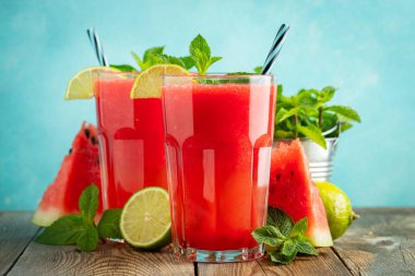 Kireç ve nane ile Karpuz slushie, açık mavi arka plan üzerinde uzun boylu gözlük yaz ferahlatıcı içecek. Tatlı soğuk smoothie