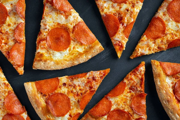 Pizza gustoasă cu pepperoni pe fundal din beton negru. Vedere de top a pizza fierbinte cu pepperoni. Plat lay — Fotografie, imagine de stoc