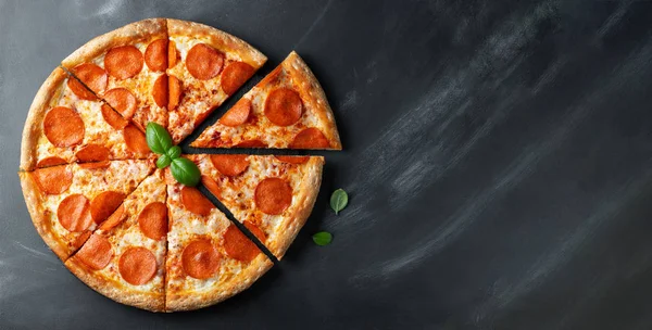 Pizza pepperoni lezat dengan latar belakang beton hitam. Pemandangan peperoni pizza panas. Dengan ruang fotokopi untuk teks. Berbaringlah. Banner — Stok Foto