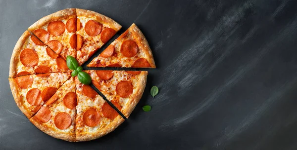 Siyah beton arka plan üzerinde lezzetli pepperoni pizza. Acı biberli pizzanın en iyi görünümü. Metin için kopyalama alanı ile. Düz yatıyordu. Afiş