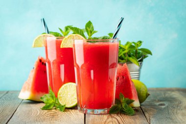 Kireç ve nane ile Karpuz slushie, açık mavi arka plan üzerinde uzun boylu gözlük yaz ferahlatıcı içecek. Tatlı soğuk smoothie