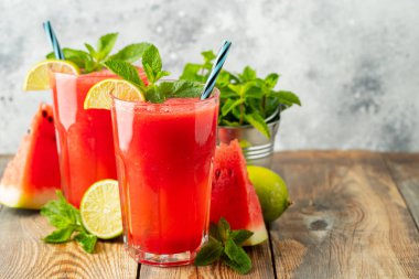Kireç ve nane ile Karpuz slushie, açık mavi arka plan üzerinde uzun boylu gözlük yaz ferahlatıcı içecek. Kopya alanı ile tatlı soğuk smoothie