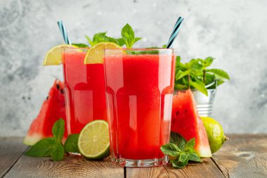 Kireç ve nane ile Karpuz slushie, açık mavi arka plan üzerinde uzun boylu gözlük yaz ferahlatıcı içecek. Tatlı soğuk smoothie