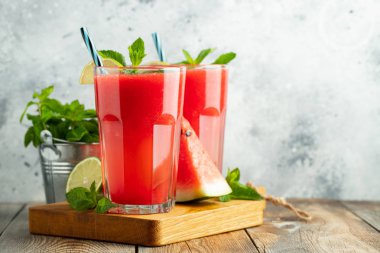 Kireç ve nane ile Karpuz slushie, açık mavi arka plan üzerinde uzun boylu gözlük yaz ferahlatıcı içecek. Kopya alanı ile tatlı soğuk smoothie