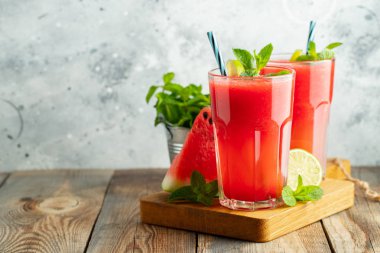 Kireç ve nane ile Karpuz slushie, açık mavi arka plan üzerinde uzun boylu gözlük yaz ferahlatıcı içecek. Kopya alanı ile tatlı soğuk smoothie