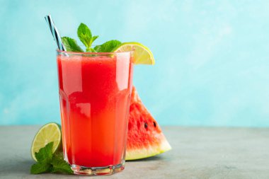 Kireç ve nane ile Karpuz slushie, açık mavi arka plan üzerinde uzun boylu gözlük yaz ferahlatıcı içecek. Kopya alanı ile tatlı soğuk smoothie