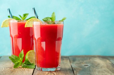 Kireç ve nane ile Karpuz slushie, açık mavi arka plan üzerinde uzun boylu gözlük yaz ferahlatıcı içecek. Kopya alanı ile tatlı soğuk smoothie