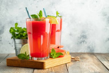 Kireç ve nane ile Karpuz slushie, hafif bir arka plan üzerinde uzun bardak yaz ferahlatıcı içecek. Kopya alanı ile tatlı soğuk smoothie