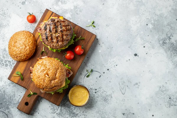 Lezzetli ızgara ev kopya alanı ile hafif bir taş arka plan üzerinde sığır eti, domates, peynir, pastırma ve marul ile burger yaptı. Üst te. fast food ve abur cubur kavramı. Düz yatıyordu