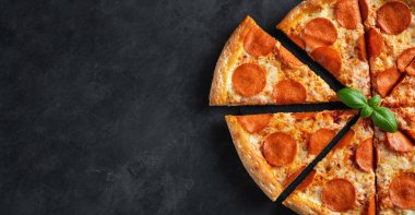 Lezzetli pepperoni pizza ve pişirme malzemeleri domates fesleğen üzerinde 