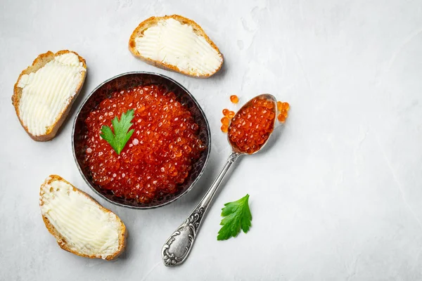 Delicious red caviar in black bowl on a light concrete backgroun — Stock Photo, Image