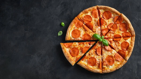 Chutná papriková pizza a přísady do vaření rajčata bazalka na černém betonu pozadí. Horní pohled na hot pepperoni pizzu. S prostorem pro kopírování textu. Ležel. Nápis — Stock fotografie