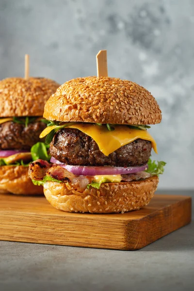 Hafif beton arka planda sığır eti, pastırma, peynir, marul ve domates ev yapımı lezzetli burger bir dizi. Yağ sağlıksız gıda yakın çekim